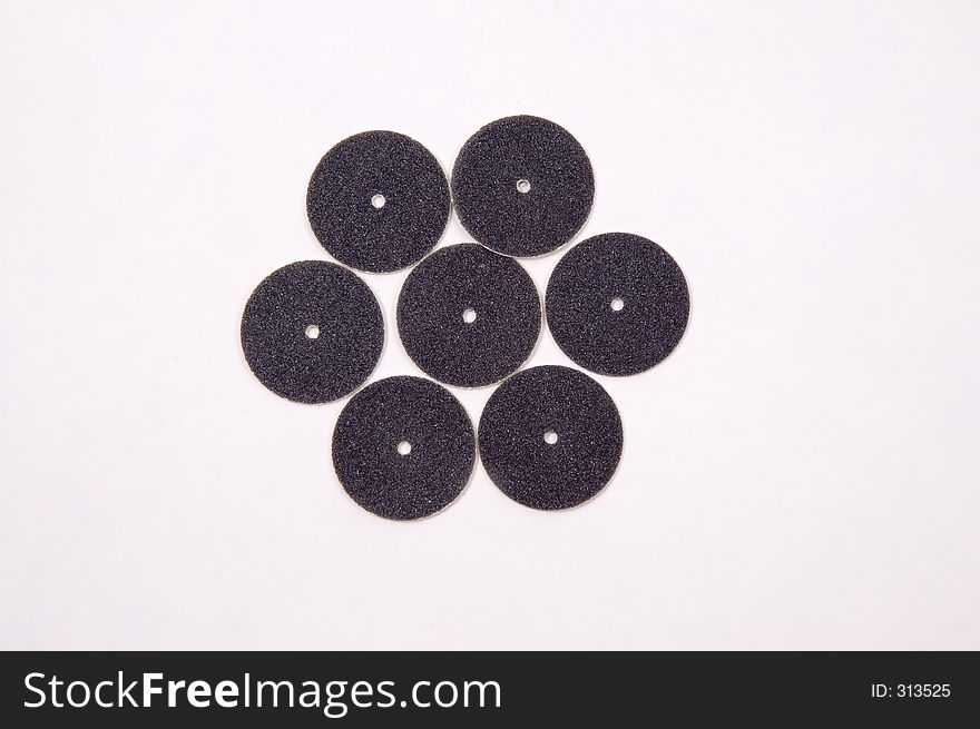 7 miniature sanding discs arranged on a white background