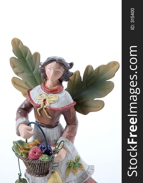 close up of a figure used for decoration at Thanksgiviing. Wooden Angel with leaves for wings. close up of a figure used for decoration at Thanksgiviing. Wooden Angel with leaves for wings