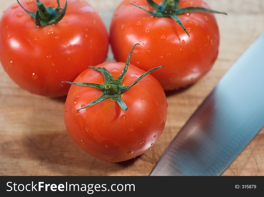 Red, ripe tomatoes on cutting board with knife. Red, ripe tomatoes on cutting board with knife