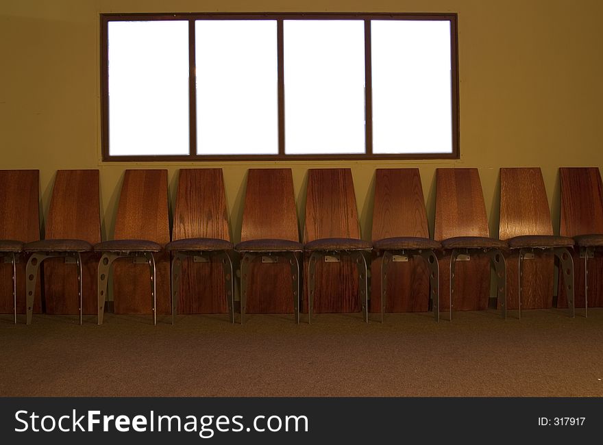 Several chair in a row in front of white windows. Several chair in a row in front of white windows