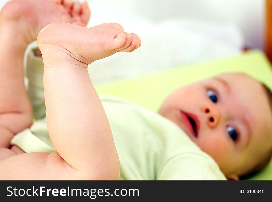 Baby infant holding his own feet. Baby infant holding his own feet