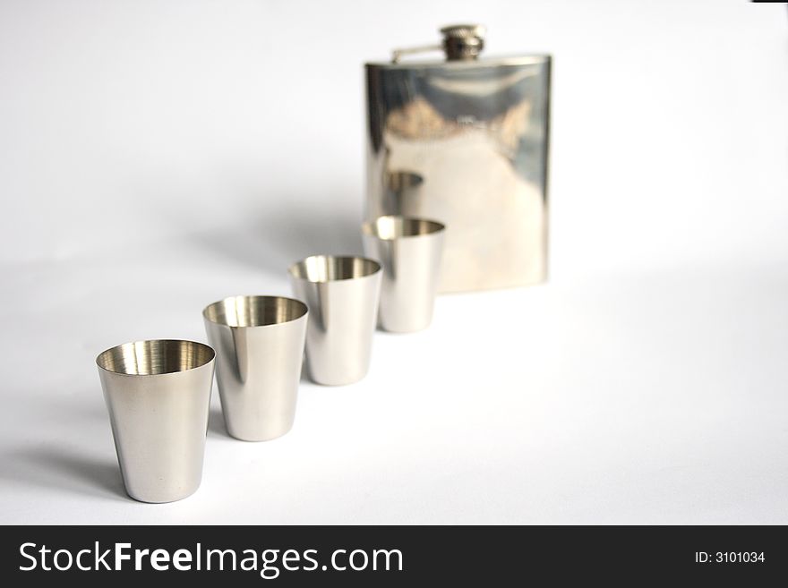 On a photo iron wine-glasses and a flask from iron. The photo is isolated