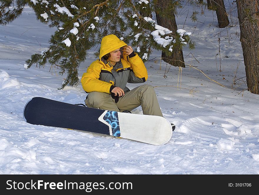 Almaty. Tien Shan. Snowboarder sitting down on the snow.