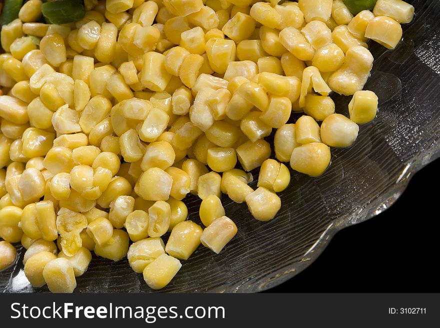 Precooked corn on a glass dish on a black background