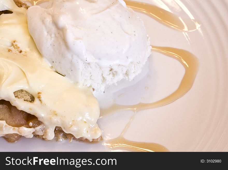 Slice of apple pie frosted with vanilla ice cream on white plate. Slice of apple pie frosted with vanilla ice cream on white plate