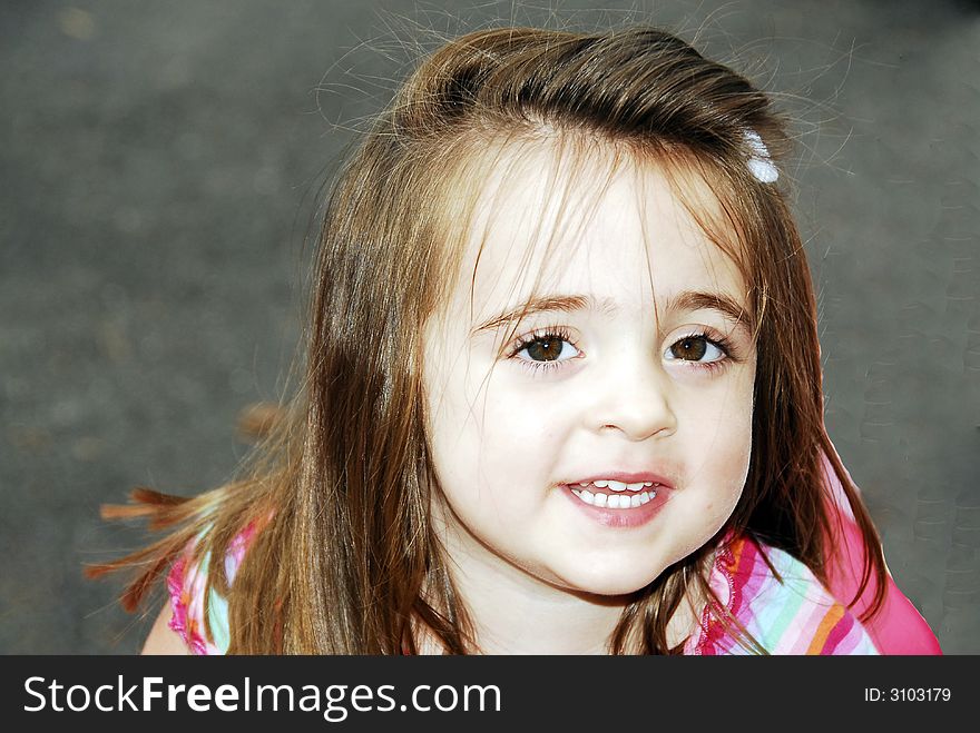 Beautiful brunette with big brown eyes showing her teeth looking sweet even with her hair a little messed up. Beautiful brunette with big brown eyes showing her teeth looking sweet even with her hair a little messed up.