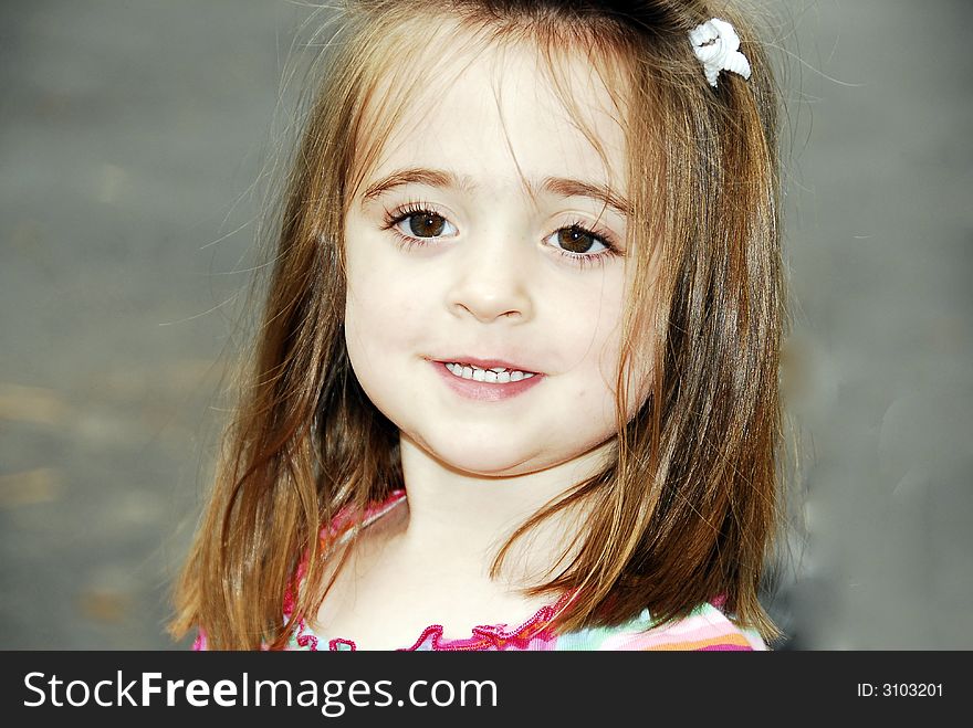 Beautiful brunette with big brown eyes showing her teeth looking sweet even with her hair a little messed up. Beautiful brunette with big brown eyes showing her teeth looking sweet even with her hair a little messed up.