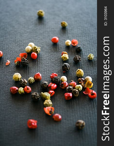 Colorful hot pepper grains on a black background. Colorful hot pepper grains on a black background