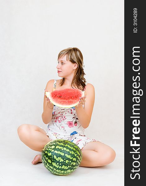 A sitting girl with a water melon in her hands. A sitting girl with a water melon in her hands