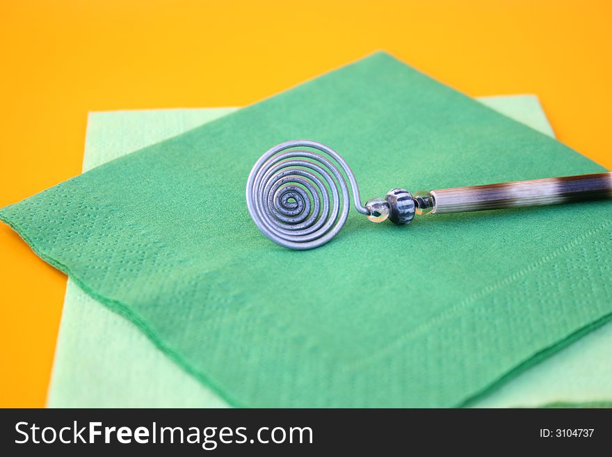 Olive Spoon on green napkins and an orange background. Olive Spoon on green napkins and an orange background