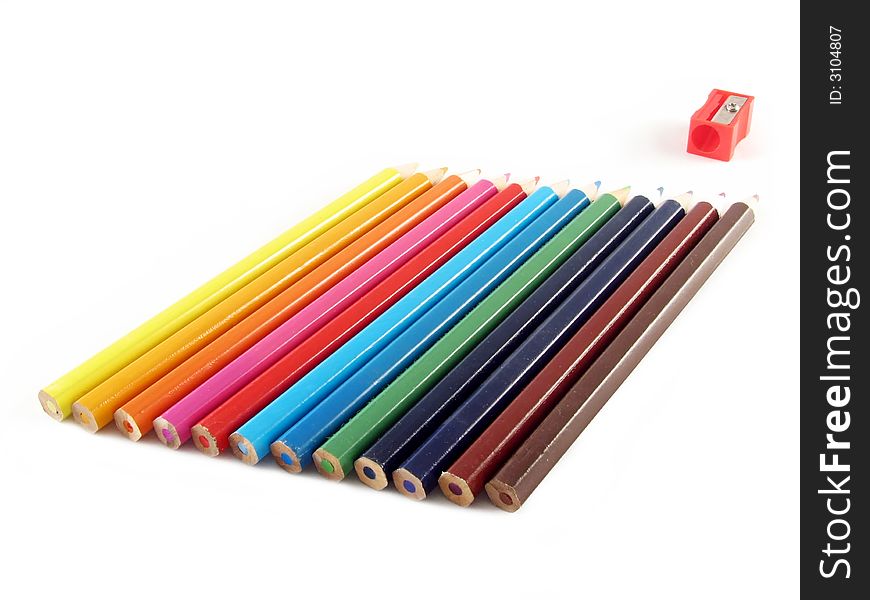 School and office articles: coloured pencils and pencil sharpener on white background