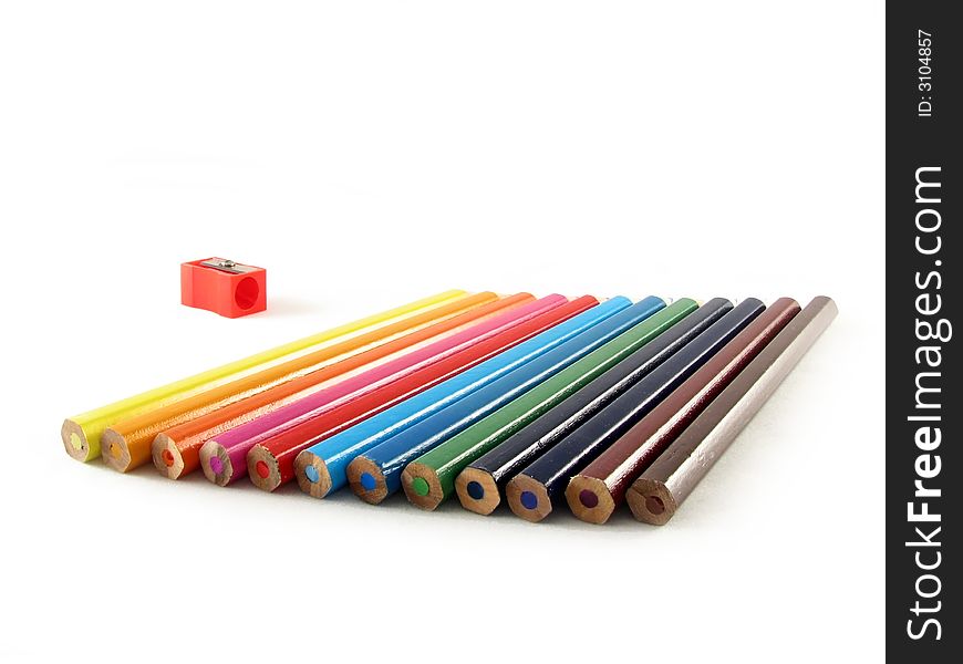 School and office articles: coloured pencils and pencil sharpener on white background