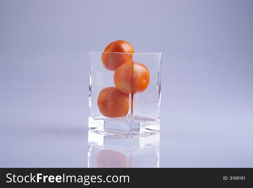 Three tangerines in a glass
