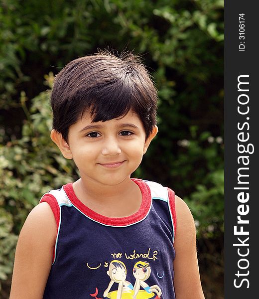 A vertical portrait of a pretty little preschool girl with a happy smile as she poses outdoors. A vertical portrait of a pretty little preschool girl with a happy smile as she poses outdoors.