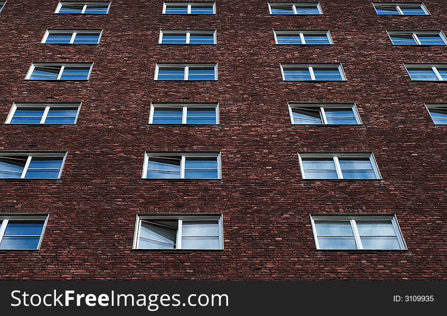 Windows on an apartment building, reflecting the skies above.