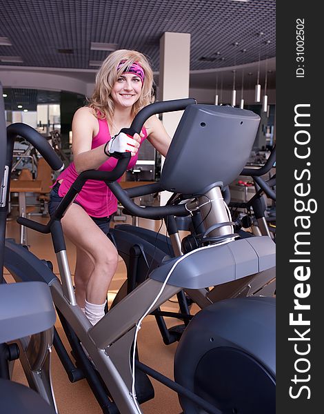 Beautiful blonde womanr doing exercise on bike in gym. Beautiful blonde womanr doing exercise on bike in gym