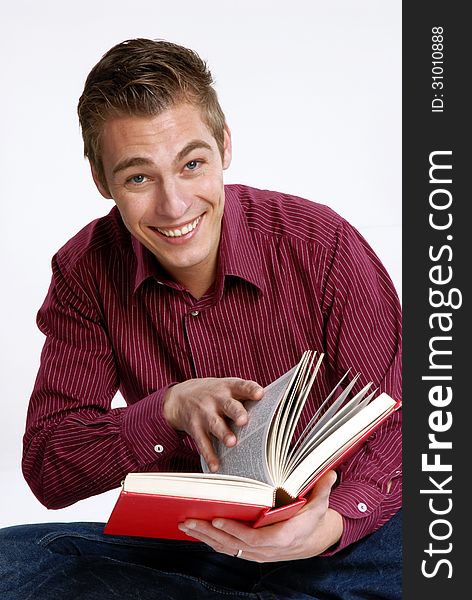 Happy young man holding and reading a book. Happy young man holding and reading a book.