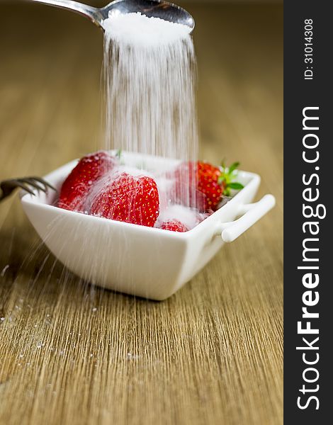 Sugar being poured over strawberries. motion blur. Sugar being poured over strawberries. motion blur