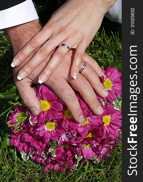 Wedding rings on the hands of the newlyweds