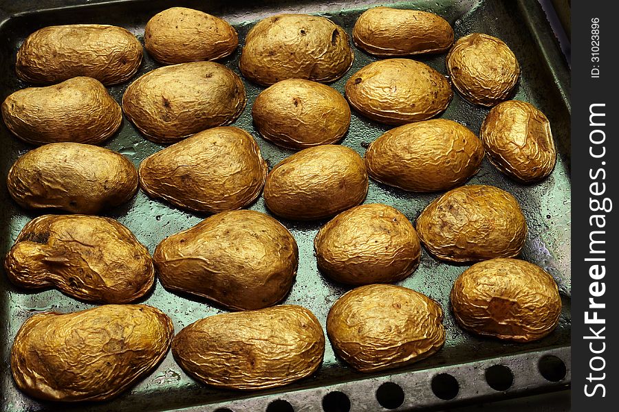 Baked in the oven potatoes on a baking tray. Baked in the oven potatoes on a baking tray