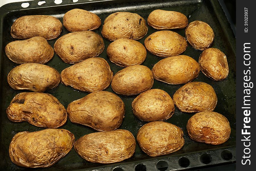 Baked in the oven potatoes on a baking tray. Baked in the oven potatoes on a baking tray