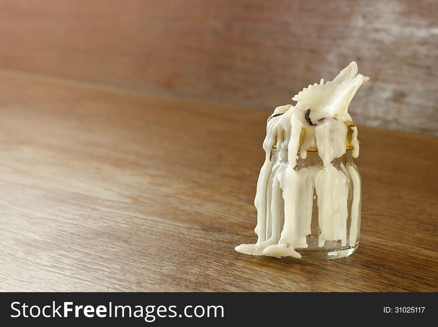 Old candle on wooden background