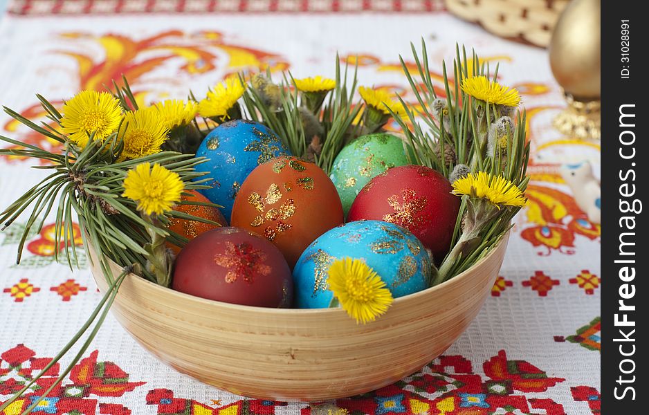 Colored small eggs in a basket by Easter