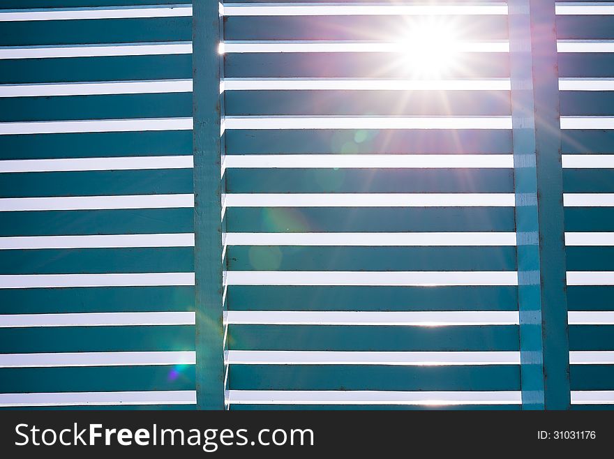 Blue wooden lath with strong sun lens flare. Blue wooden lath with strong sun lens flare