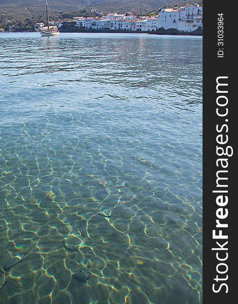 Beautiful sun dappled green-blue water of Cadaques Bay, Spain