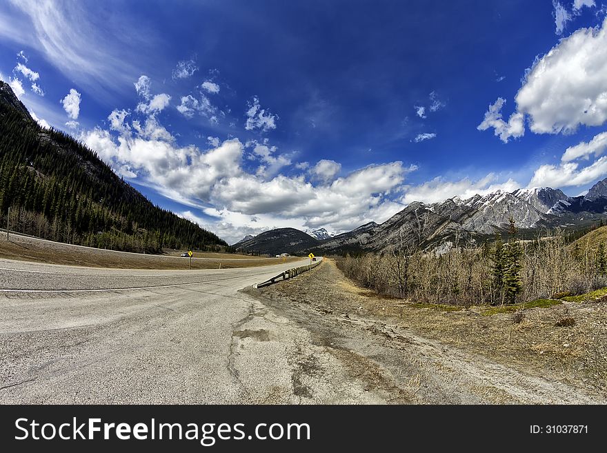 Road in the Canadian rocky mountains in Spring thru a fisheye lens. Road in the Canadian rocky mountains in Spring thru a fisheye lens