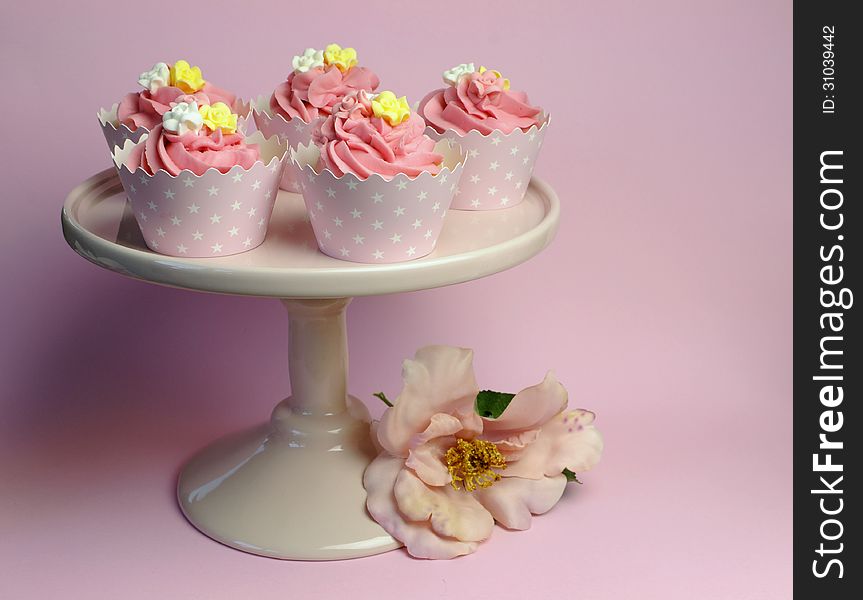 Beautiful pink decorated cupcakes on pink cake stand for birthday, wedding or female special event occasion,with pink flower. Beautiful pink decorated cupcakes on pink cake stand for birthday, wedding or female special event occasion,with pink flower.