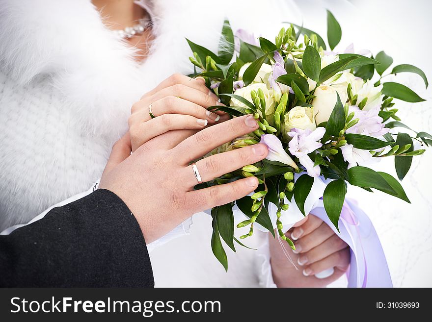 Hands with wedding gold rings and flowers