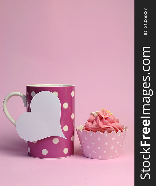 Pink polka dot coffee mug with pink cupcake and blank white heart shape gift tag - Vertical with copy space.