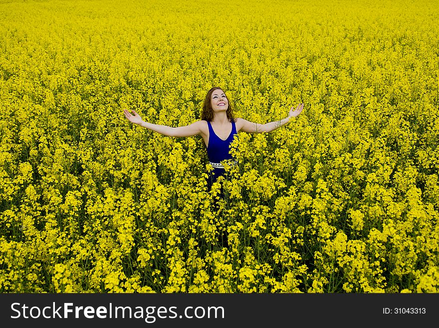 Happy teenager beauty with blue dress in canola field. Happy teenager beauty with blue dress in canola field