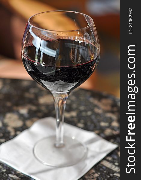 Glass of Red Wine (Cabernet Sauvignon or Merlot) served in a restaurant. Glass of Red Wine (Cabernet Sauvignon or Merlot) served in a restaurant