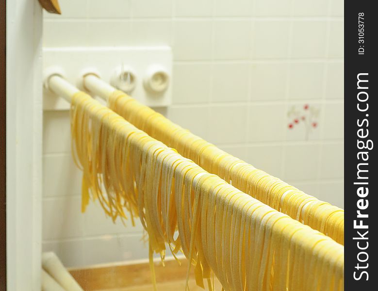 Fresh made fettuccine pasta drying on a rack. Fresh made fettuccine pasta drying on a rack