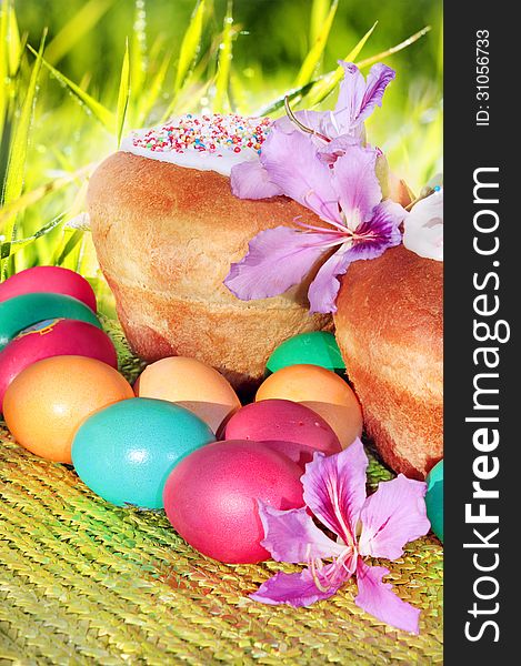 Freshly baked Easter cakes and painted eggs on the background of blurred grass. Freshly baked Easter cakes and painted eggs on the background of blurred grass