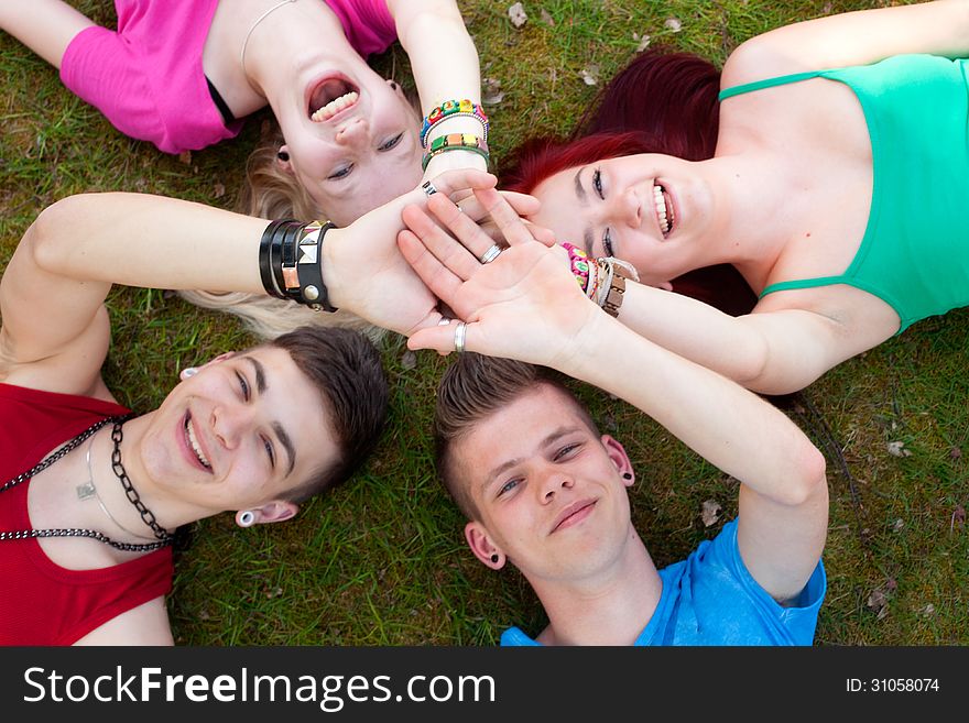 Four teenagers are having fun in the grass. Four teenagers are having fun in the grass