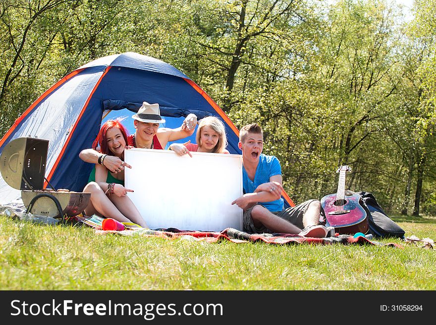 Teenagers on a camping with an empty sign board