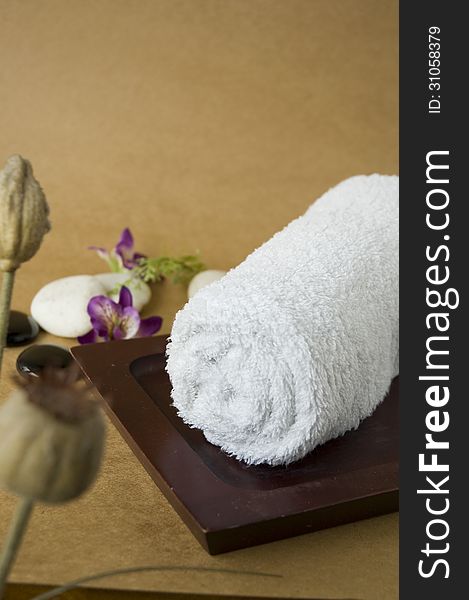 White towel roll on wooden tray for spa treatment. White towel roll on wooden tray for spa treatment