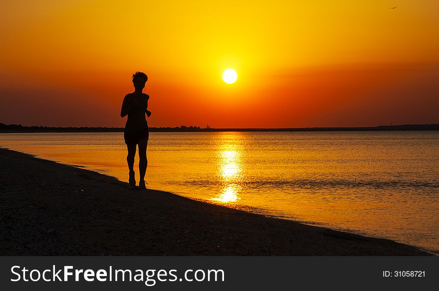 Silhouette of woman runing along the sea coast. Silhouette of woman runing along the sea coast