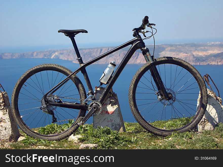 Biking on the edge of a cliff on the background of the mountains and the sea. Biking on the edge of a cliff on the background of the mountains and the sea