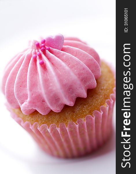 A tiny pink cupcake isolated on white background.