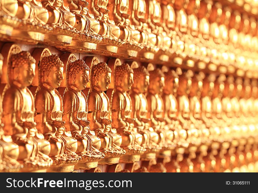 A wall of golden Thousand Buddha in a temple with shallow depth pf field. A wall of golden Thousand Buddha in a temple with shallow depth pf field.