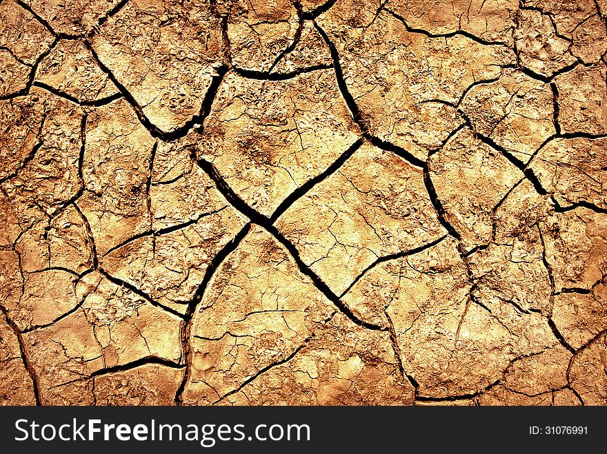 The cracks on the parched earth at the bottom of the dried-up lake