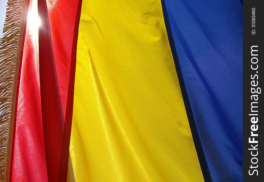Flag of Romania waving and illuminated by sunlight