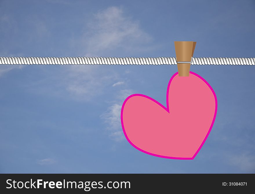 Pink heart hanged on white rope in front of blue sky