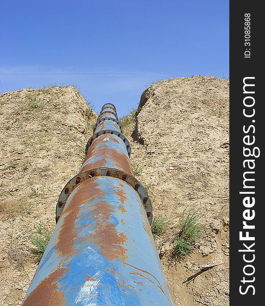 Photography with scene of the pipe line on background of the sandy territory