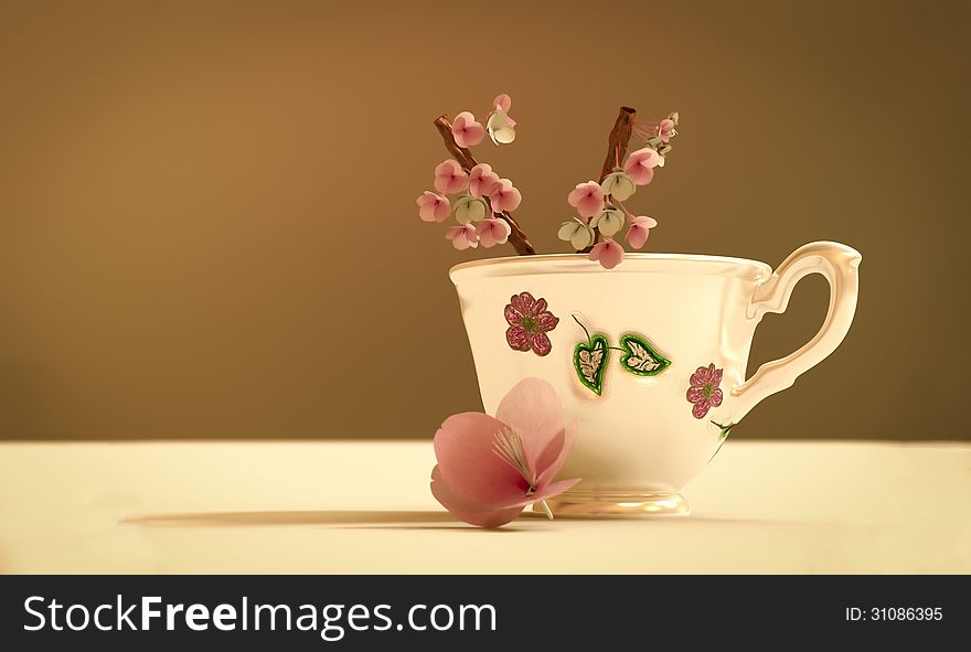 Teapot with cherry flower on blurred background. Teapot with cherry flower on blurred background.