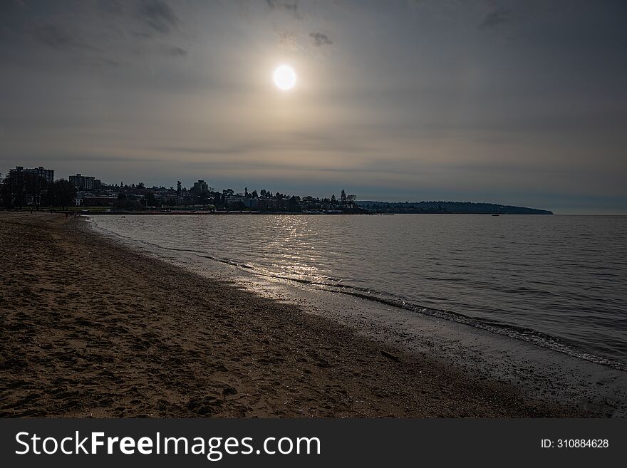 This photo was taken on a cloudy day in Vancouver's English Bay, with strong sunlight shining through clouds. This photo was taken on a cloudy day in Vancouver's English Bay, with strong sunlight shining through clouds.